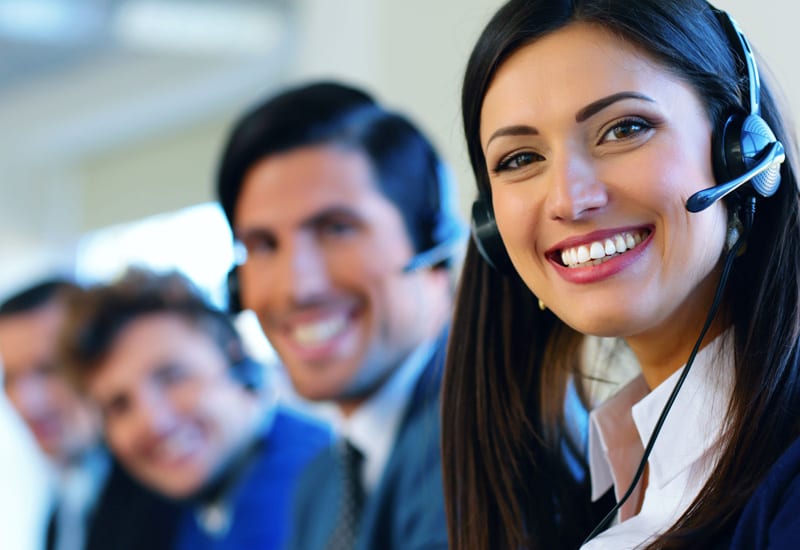 24/7 IT Service Desk Operators with Headsets Smiling in Office