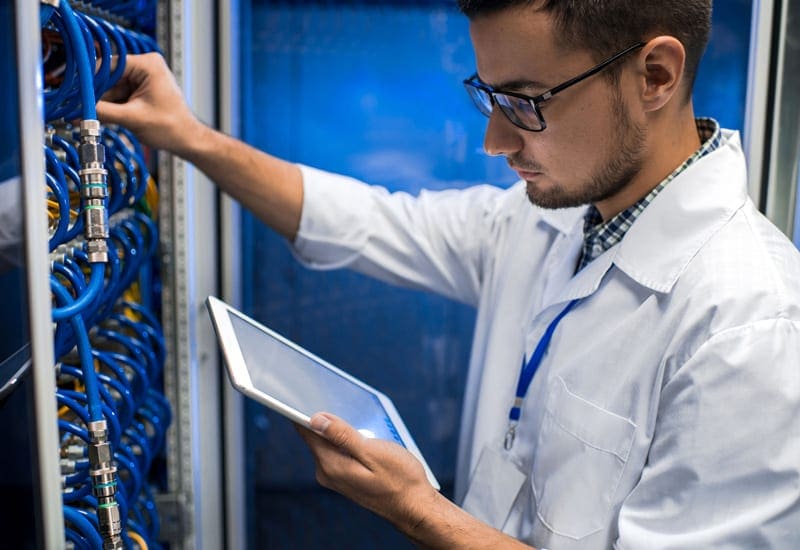 Network Engineer with Tablet working in a Server Rack